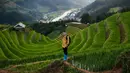 Pengunjung berfoto dengan latar belakang sawah terasering di distrik Mu Cang Chai, Vietnam utara pada 18 September 2020. Pesawahan terasering di Mu Cang Chai merupakan destinasi-destinasi wisata yang atraktif dan menyerap kedatangan  banyak wisatawan domestik dan mancanegara. (Manan VATSYAYANA/AFP)