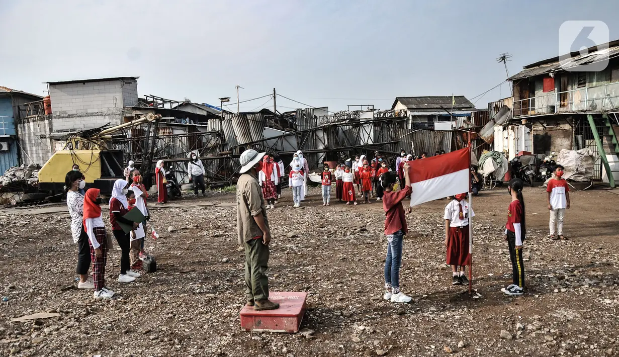 Petugas upacara mengibarkan  bendera Merah Putih saat pacara memperingati Hari Kemerdekaan ke-76 Republik Indonesia di Cilincing, Jakarta, Selasa (17/8/2021). (merdeka.com/Iqbal S. Nugroho)