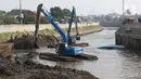 Petugas menggunakan alat berat melakukan proses pengerukan endapan tanah di aliran Sungai Ciliwung, Jakarta, Selasa (28/7/2020). Pengerukan endapan ini untuk memperlancar aliran air Sungai Ciliwung serta upaya pencegahan banjir saat musim hujan. (Liputan6.com/Helmi Fithriansyah)