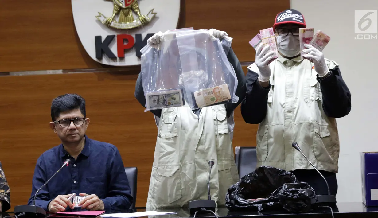 Wakil Ketua KPK, La Ode Muhammad Syarif (kiri) melihat barang bukti uang hasil OTT di Gedung KPK, Jakarta, Sabtu (26/6/2019). Dalam OTT tersebut, KPK menahan dua jaksa, dua pengacara dan satu orang dari swasta. (Liputan6.com/Helmi Fithriansyah)