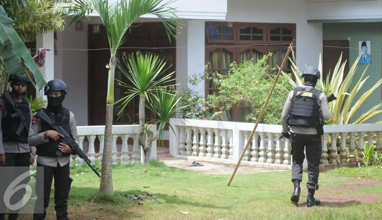 Petugas Kepolisian Brimob berjaga disekitar area rumah terduga teroris di Setu, Tangerang Selatan, Rabu (21/12). Pada saat penggerebekan, terjadi perlawanan hingga mengakibatkan tewasnya ketiga tersangka (Liputan6.com/Helmi Affandi)