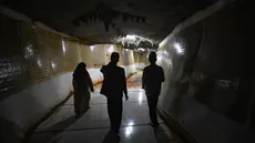 Pengunjung berjalan sambil mengamati ayat-ayat Al Quran yang ditempel pada dinding Gua di Desa Cinangneng, Tenjolaya, Kabupaten Bogor, Jawa Barat, Selasa (11/3/2025). (merdeka.com/Arie Basuki)