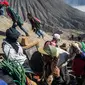 Warga Tengger mendaki Gunung Bromo membawa persembahan hasil bumi selama Festival Yadnya Kasada di Probolinggo, Jawa Timur (10/7). Warga Tengger melakukan ritual lempar hasil bumi sebagai wujud syukur pada Sang Hyang Widi. (AFP Photo/Juni Kriswanto)