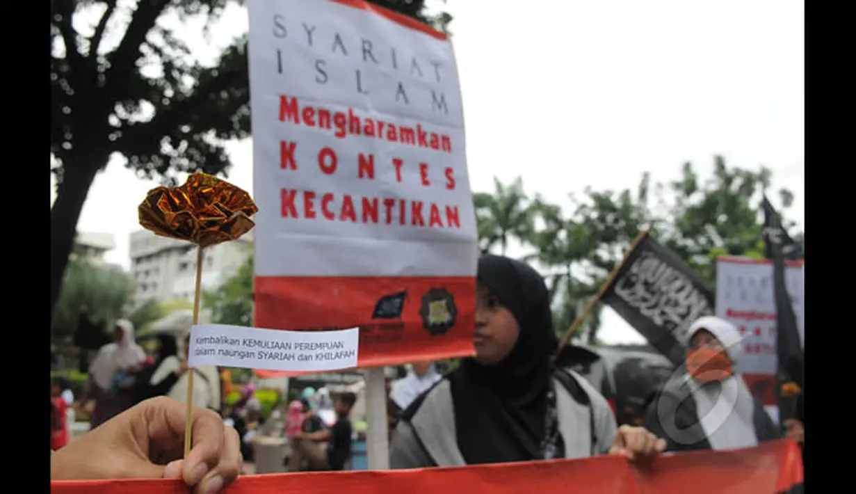 Aksi massa dari Hizbut Tahrir Indonesia (HTI) melakukan aksi unjuk rasa menolak kontes Putri Indonesia di depan kantor Kementerian Pemberdayaan Perempuan, Jakarta, Jumat (20/2/2015). (Liputan6.com/Herman Zakharia)