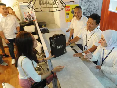 Direktur Manajemen Resiko BNI Bob Tyasika Nanta melayani nasabah saat Hari Pelanggan Nasional di Kantor BNI Mall  Kota Kasablanka, Jakarta, Selasa (4/9). Pada Hari Pelanggan Nasional ini BNI memperlakukan nasabah secara istimewa. (Merdeka.com/Arie Basuki)