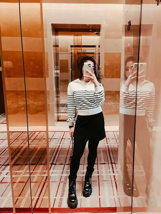 Kali ini ia tampil kasual mengenakan striped long sleeve tee, dipadukan dengan mini skirt dan long pants warna hitam senada. Gayanya dilengkapi dengan sepatu boots hitam. @nikitawillyofficial94.