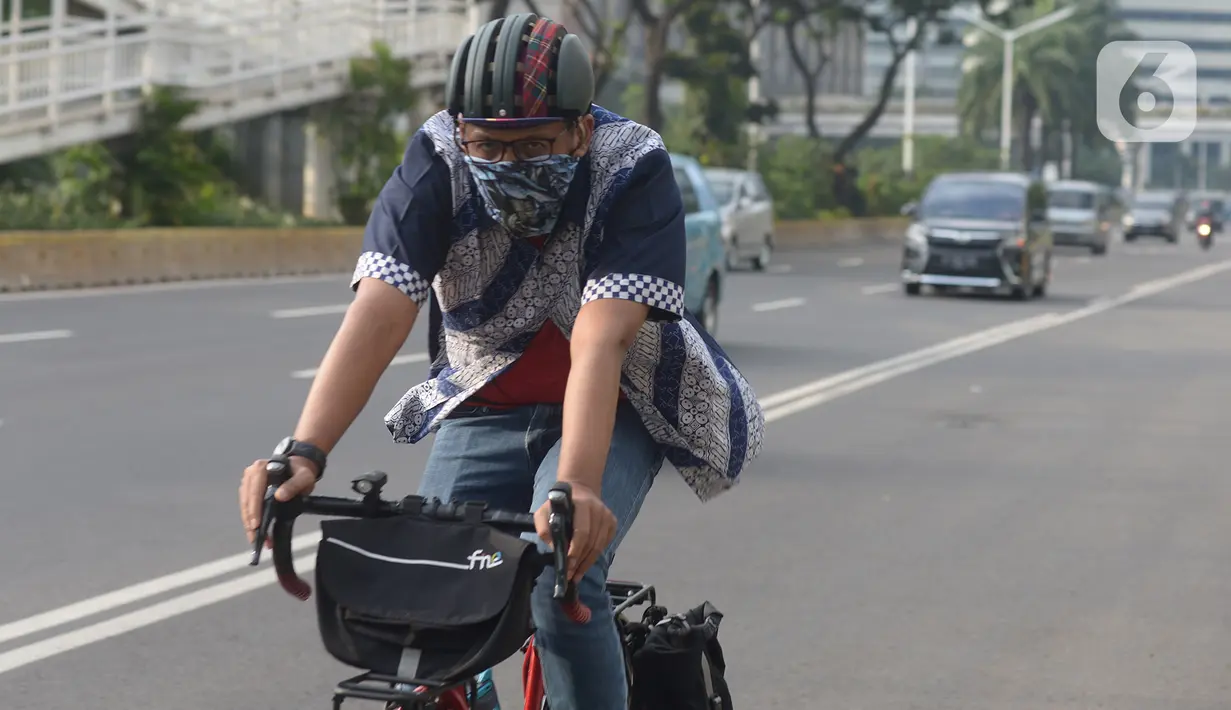 Seorang pria yang mengenakan baju batik bersepeda di kawasan Thamrin Sudirman, Jakarta, Jumat (2/10/2020). Pada Hari Batik Nasional yang berlangsung di tengah pandemi COVID-19, sebagian masyarakat terlihat mengenakan baju dan masker dengan motif batik. (merdeka.com/Imam Buhori)