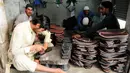 Seorang pembuat sepatu asal Pakistan membuat sepatu tradisional yang dikenal sebagai "chapli" di kalangan penduduk lokal untuk menyambut Hari Raya Idul Fitri di Peshawar, Pakistan barat laut, pada 19 Mei 2020. (Xinhua/Saeed Ahmad)