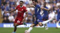 Bek sayap Liverpool, Trent Alexander-Arnold (merah) saat membayangi pergerakan bek Chelsea, Ben Chilwell dalam pertandingan pertama Liga Inggris 2023/2024 di Stamford Bridge, Minggu (13/8/2023) malam WIB. (AP Photo/Ian Walton)