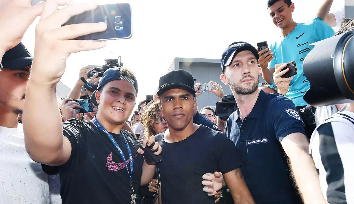 Sejumlah fans mengajak gelandang Bayern Munchen, Douglas Costa, foto bersama saat akan menjalani tes medis bersama Juventus di Juventus Medical Center, Turin, Rabu (12/7/2017). (EPA/Alessandro Di Marco)