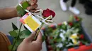 Mawar yang disertai sebuah pesan dibagikan kepada para pejalan kaki di London Bridge, Minggu (11/6). Muslim Inggris membagikan ratusan mawar sebagai bentuk solidaritas menyusul serangan teror London yang terjadi pekan lalu. (Ben STANSALL/AFP)