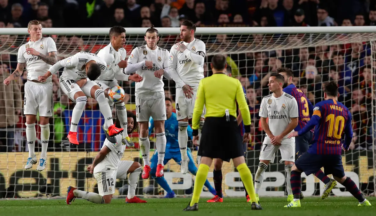 Penyerang Barcelona Lionel Messi (kanan) melakukan tendangan bebas ke gawang Real Madrid saat bertanding pada leg pertama semifinal Copa del Rey di Stadion Camp Nou, Barcelona, Spanyol, Rabu (6/2). Pertandingan berakhir 1-1. (AP Photo/Manu Fernandez)