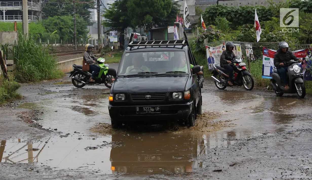 Kendaraan menghindari kubangan pada jalan yang rusak di Jalan Pertamina, Kemiri Muka, Depok, Jawa Barat, Selasa (5/3). Kondisi tersebut mengganggu aktivitas warga serta pengguna jalan. (Liputan6.com/Immanuel Antonius)