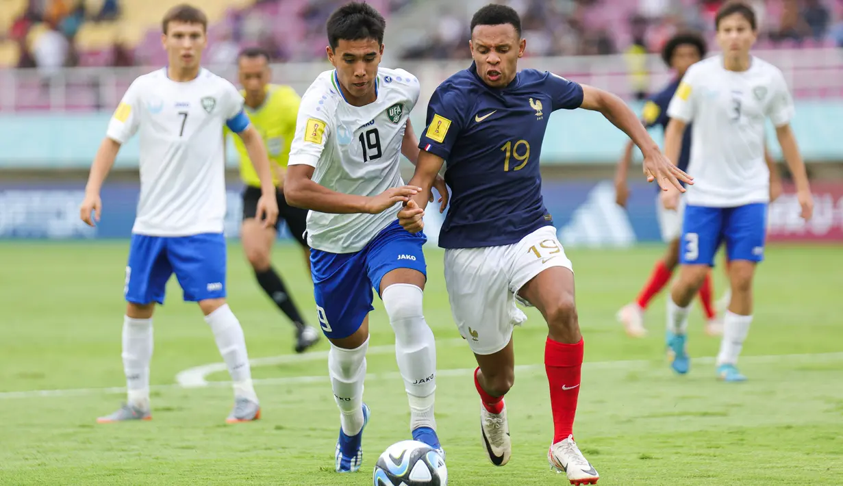 Pemain Timnas Prancis Joan Tincres berebut bola dengan pemain Timnas Uzbekistan Sherzodbek Abdulboriev pada pertandingan perempat final Piala Dunia U-17 2023 di Stadion Manahan, Solo, Jawa Tengah, Sabtu (25/11/2023). (LOC WCU17/NFL)