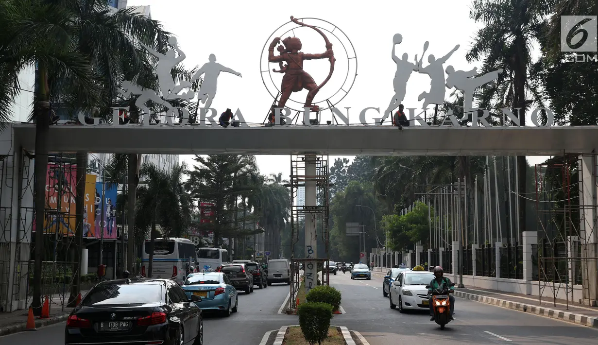 Pekerja beraktivitas membersihkan gerbang masuk jalan Pintu Satu Senayan, Jakarta, Jumat (20/7). Jelang perhelatan Asian Games 2018, sejumlah fasilitas penunjang di kawasan Gelora Bung Karno terus dipercantik. (Liputan6.com/Helmi Fithriansyah)
