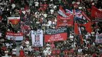 Suporter mengibarkan bendera dan membentangkan spanduk di tribun penonton selama pertandingan Premier League antara Manchester United dan Arsenal di Old Trafford, Manchester, Inggris barat laut, pada 17 Agustus 2025. (Paul ELLIS/AFP)