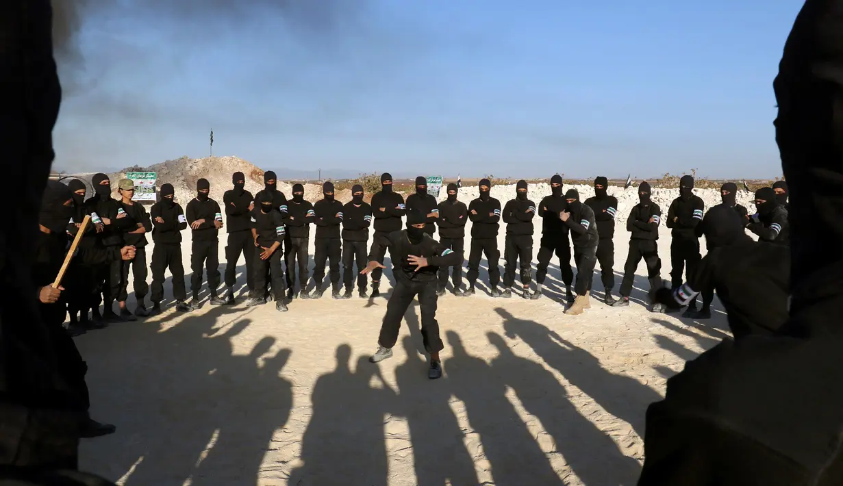Sejumlah pasukan pemberontak melihat aksi bela diri saat mengikuti latihan militer di provinsi Idlib, Suriah, (27/10). (REUTERS/Ammar Abdullah)
