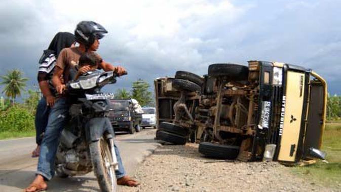 Warga memperhatikan dua truk pasir yang saling tabrakan di ...
