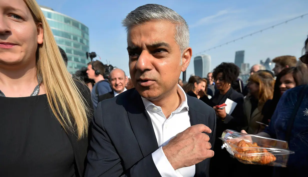Walikota London terpilih Sadiq Khan berselfie dengan pendukung saat tiba untuk hari pertamanya bekerja di Balai Kota di London, Inggris (9/5). Pria 45 tahun ini merupakan Wali Kota Muslim Pertama di London dan kedua di Eropa. (REUTERS / Hannah McKay)