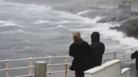 Warga melihat gelombang tinggi di pesisir Irlandia yang disebabkan oleh terjangan Badai Ophelia. (Niall Carson/PA via AP)