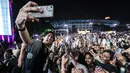 Vokalis Sheila on 7, Akhdiyat Duta Modjo melakukan swafoto bersama para penonton Kapanlagi Buka Bareng (KLBB) 2026 yang berlangsung di Stadion Madya, Senayan, Jakarta, Minggu (01/03/2026). (Bola.com/Bagaskara Lazuardi)