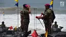 Panglima TNI Marsekal Hadi Tjahjanto (kiri) memakai baret ungu sebagai tanda telah menjadi warga kehormatan Korps Marinir di Pantai Nganteb, Malang, Jawa Timur, Kamis (22/2). (Liputan6.com/HO/Marinir TNI-AL)