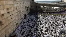 Ribuan umat Yahudi menggelar doa di Tembok Barat Kota Tua Yerusalem, Senin (2/4). Ritual memperingati penderitaan eksodus bangsa Israel dari Mesir ini berlangsung delapan hari selama libur Paskah. (MENAHEM KAHANA/AFP)