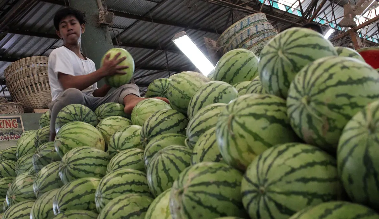 Pekerja mengangkut buah segar di Pasar Induk Kramat Jati, Jakarta, Selasa (9/6/2015). Jelang Ramadan, permintaan buah segar dari Dalam Kota meningkat hingga 100 persen. Buah Blewah dijual  Rp6.000/kg dan Semangka  Rp7.000/kg. (Liputan6.com/Helmi Afandi)