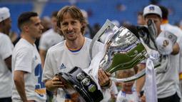 Gelandang Real Madrid, Luka Modric berpose dengan trofi untuk merayakan gelar La Liga Spanyol usai pertandingan melawan Espanyol di stadion Santiago Bernabeu di Madrid, Sabtu  (30/4/2022). Madrid tak terkejar lagi oleh Sevilla (64 poin) di sisa empat laga dan juga Barcelona (63 poin) di posisi ketiga. (AP Photo/Bernat Armangue)