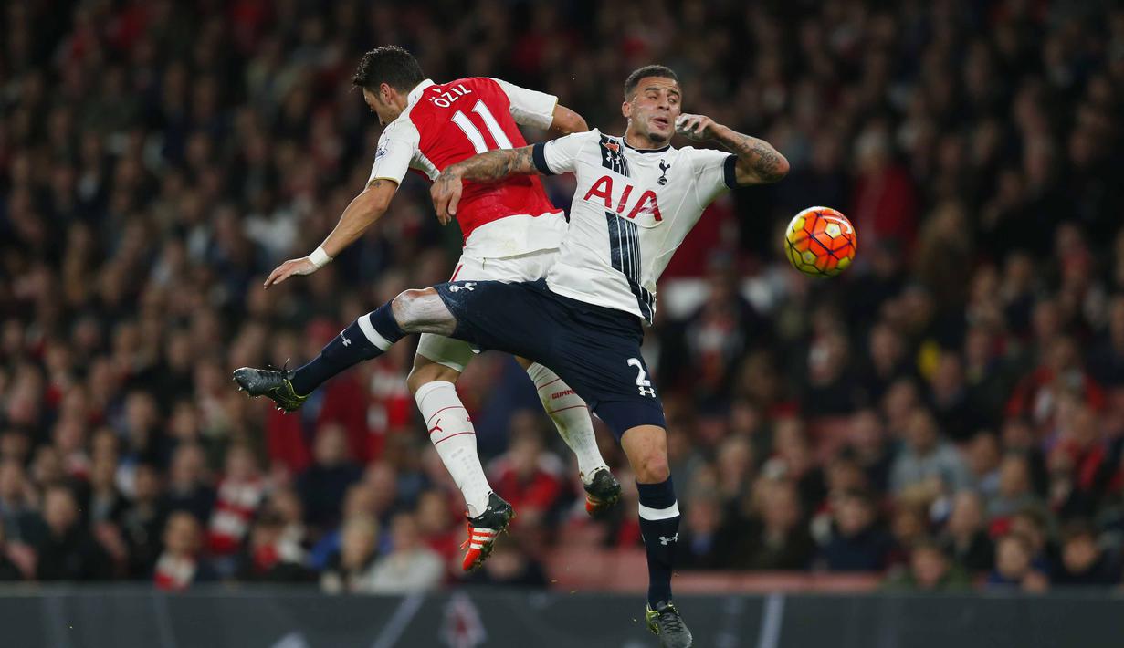 Pemain Arsenal Mesut Ozil berebut bola dengan pemain Tottenham Hotspur Kyle Walker pada lanjutan Liga Premier Inggris  di Stadion Emirates, London, Inggris, Minggu (8/11/2015). Arsenal bermain imbang 1-1.   (Reuters / Eddie Keogh)
