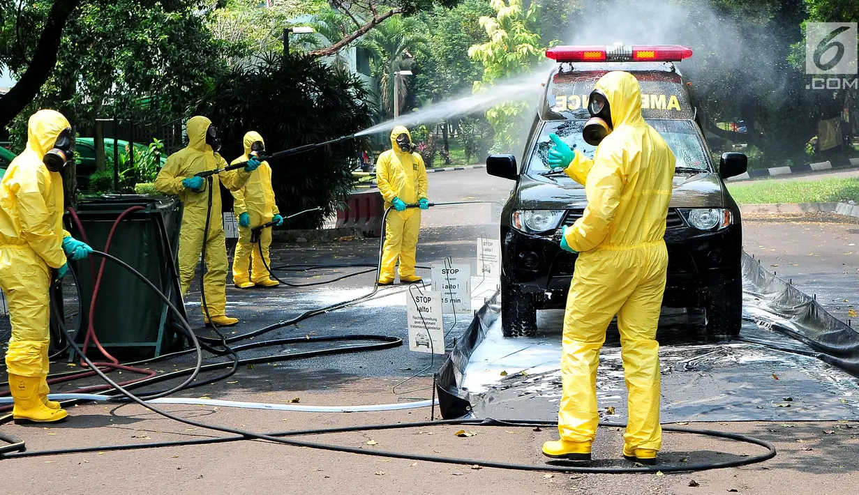 Tim Pasukan Gerak Cepat (PGC) melakukan sterilisasi sebuah mobil yang kedapatan positif terjangkit pandemi influenza saat simulasi penanganan Episenter Pandemi Influenza di Puspiptek Tangerang Selatan, Rabu (20/9). (Liputan6.com/Helmi Afandi)