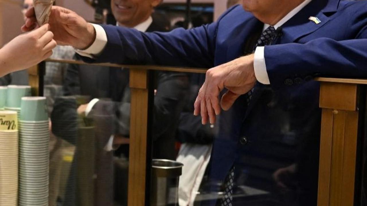 Presiden AS Joe Biden saat menerima es krim sebelum dinikmati bersama pembawa acara Seth Meyers di Van Leeuwen Ice Cream. Foto: AFP / JIM WATSON