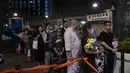 Para penggemar penyanyi dan penulis lagu Coco Lee, berkumpul dengan membawa bunga untuk memberikan penghormatan kepada idola mereka di pemakamannya di Hong Kong pada hari Senin. (AP Photo/Louise Delmotte)