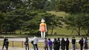 Pengunjung melihat boneka 'Younghee' yang menjadi maskot dalam serial Netflix asal Korea, Squid Game, di Olympic park, Seoul, Selasa (26/10/2021). Boneka setinggi empat meter atau 13 kaki itu, akan dipamerkan di taman tersebut selama tiga bulan. (AP Photo/Lee Jin-man)