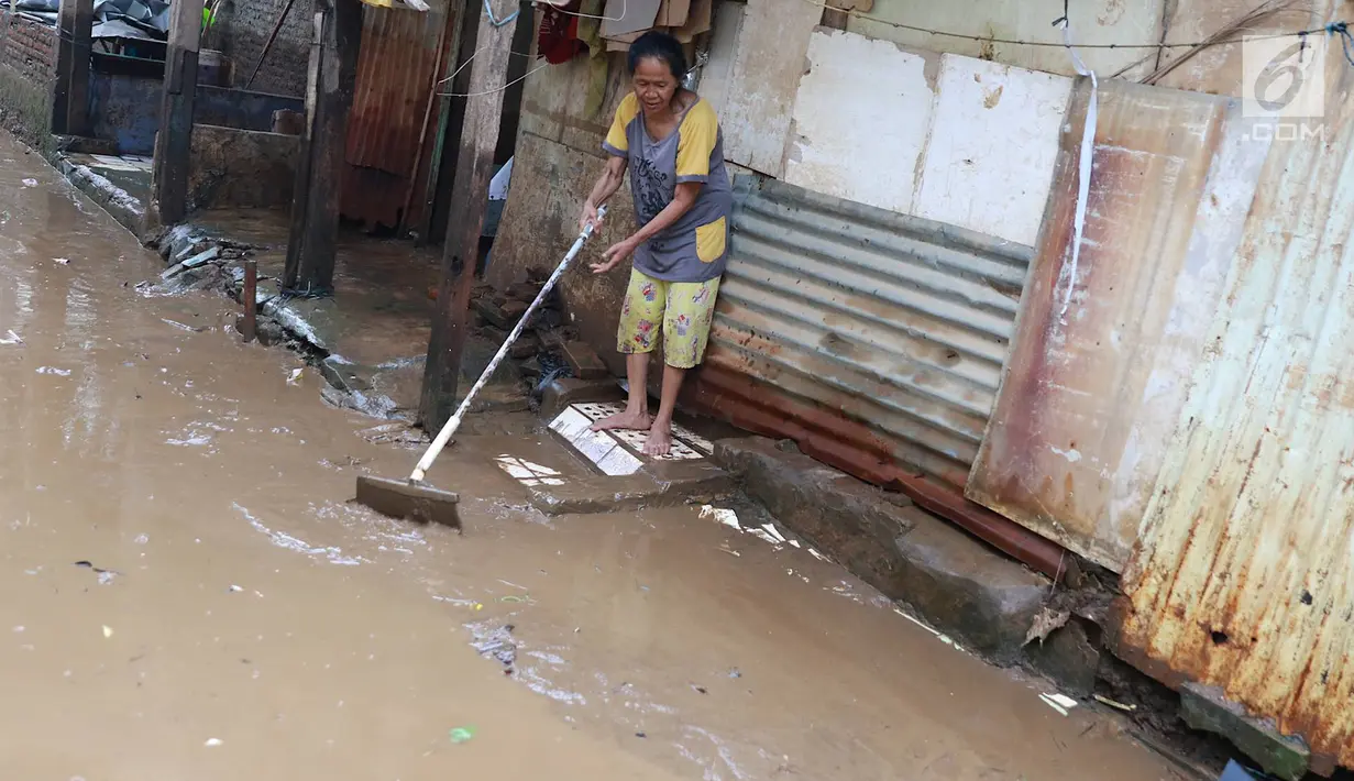 Warga membersihkan lumpur dari banjir yang menggenangi Gang Arus Dalam di Cawang, Jakarta Timur, Rabu (24/4). Banjir kiriman dari Bogor yang menggenangi kawasan tersebut menyisakan lumpur dan sampah sehingga menganggu aktivitas warga. (Liputan6.com/Immanuel Antonius)