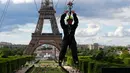 Pengunjung meluncur dengan seutas tali saat menjajal Zip Line dari lantai dua Menara Eiffel di atas taman Champ de Mars, Paris, Selasa (28/5/2019). Lintasan ini memungkinkan traveler untuk meluncur melintasi satu tempat ke tempat lainnya menggunakan tali dan alat olahraga outdoor. (AP/Francois Mori)