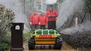 Sukarelawan menyemprotkan disinfektan dengan sebuah robot di sebuah area tempat tinggal di Wuhan di provinsi Hubei tengah China (3/3/2020). (AFP/STR)