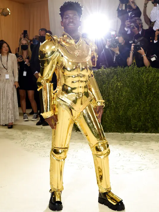 Penampilan rapper Lil Nas X menghadiri The 2021 Met Gala Celebrating In America: A Lexicon Of Fashion di Metropolitan Museum of Art, New York City, Senin (13/9/2021). Lil Nas X yang hadir di Met Gala 2021 dengan penuh totalitas tampil menggunakan 3 busana sekaligus. (Evan Agostini/Invision/AP)
