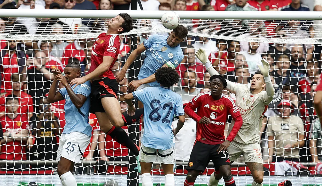 Bek Manchester City, Ruben Dias (tengah) berusaha menghalau bola dari ancaman bek Manchester United, Harry Maguire pada laga Community Shield 2024 di Wembley Stadium, London, Sabtu (10/8/2024). (AP Photo/David Cliff)