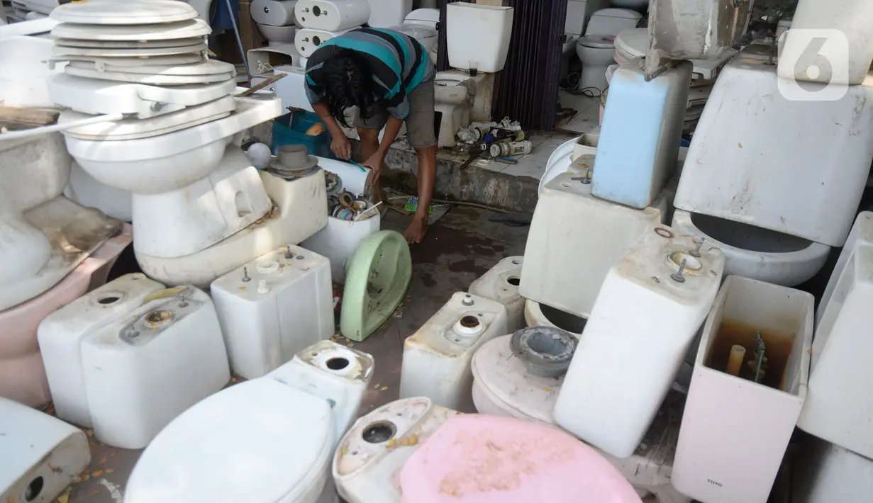 Penjual membersihkan kloset duduk bekas di Jalan Raya Ciater, Serpong, Tangerang Selatan, Banten, Jumat (13/11/2020). Kloset duduk bekas tersebut dijual dengan harga  Rp 500 ribu hingga Rp 1,5 juta pada masa pandemi Kloset bekas banyak diminati pembeli. (merdeka.com/Dwi Narwoko)