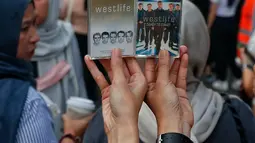 Penggemar Westlife menunjukkan album dalam bentuk fisik kaset tape saat tiba untuk menonton konser bertajuk 'The Wild Dreams Tour 2023' di kawasan Stadion Utama Gelora Bung Karno Sabtu (11/2/2023). Konser musik Westlife akan membawakan semua lagu hits mereka seperti Swear It Again, Flying Without Wings, dan World of our own serta lagu-lagu andalan dari album terbaru mereka yang bertajuk Wild Dreams. (Liputan6.com/Angga Yuniar)