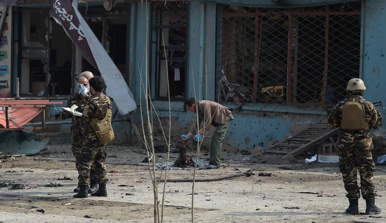 Petugas memeriksa lokasi serangan bom bunuh diri di daerah Syiah di Kabul (9/3). Seorang pembom bunuh diri yang menargetkan kelompok minoritas Afghanistan, Hazaras, meledakkan dirinya di sebuah pos pemeriksaan polisi. (AFP Photo/Shah Marai)