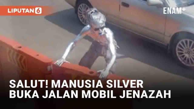 Seorang manusia silver mencuri perhatian di jalanan Sawangan, Depok. Ia terekam menggeser sejumlah water barrier saat mendengar bunyi sirine. Pria itu berusaha membuka akses jalan untuk rombongan mobil jenazah.
