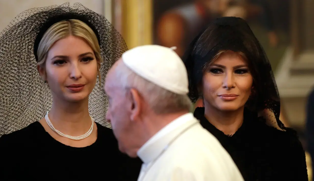 Paus Fransiskus berjalan melewati Ivanka dan Ibu Negara AS, Melania Trump pada pertemuan pribadi bersama Presiden Donald Trump di Vatikan, (24/5). Melania dan Ivanka mengenakan penutup kepala hitam saat menemui Paus. (AP Photo/Alessandra Tarantino, Pool)