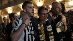 Seorang wanita dievakuasi usai terjadi ledakan saat nonton bareng final Liga Champions di Piazza San Carlo, Turin, Sabtu (3/6/2017). Acara nobar dipadati sekitar 20.000 supporter Juventus. (AFP/Marco Bertorello)