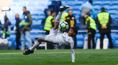 Anak Cristiano Ronaldo, Cristiano Ronaldo Jr melakukan tendangan salto usai pertandingan antara Real Madrid dan Atletico Madrid di stadion Santiago Bernabeu, Madrid (8/4). Anak Ronaldo melakukan tendangan salto meniru sang ayah. (AFP Photo/Gabriel Bouys)