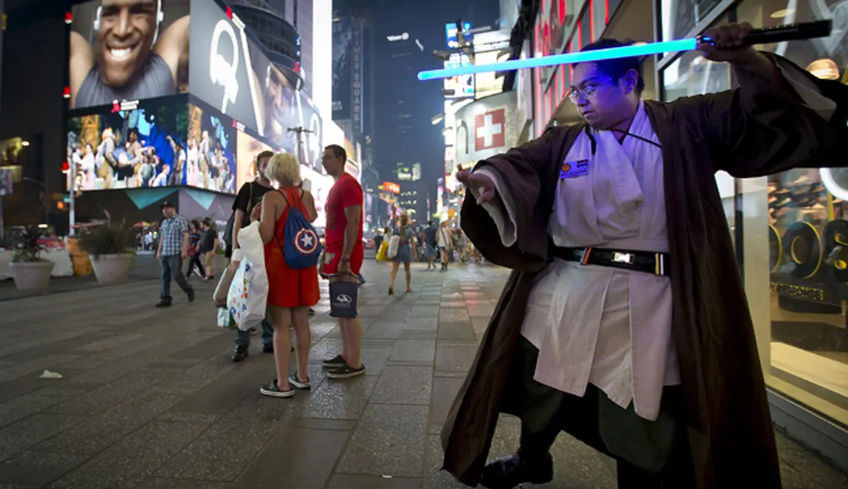 Seorang penggemar film Star Wars, Mike DeGuzman  berpose dengan lightsaber di Times Square,  New York, Jumat (4/9/2015).  Ini merupakan salah satu cara pihak Star Wars mempromosikan film dan pernak- pernik berbau film terlaris ini. (REUTERS/Carlo Allegri)