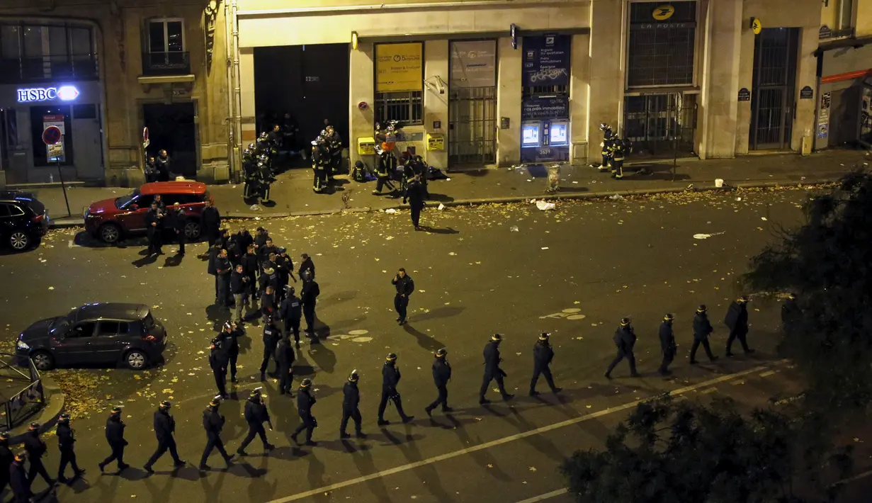 Polisi berjaga-jaga di sekitar area tempat terjadinya penembakan dan bom bunuh diri yang dilakukan teroris di Paris, Perancis, Jumat (13/11/2015). Dikabarkan ada 140 orang tewas dalam aksi teroris tersebut. (Reuters)