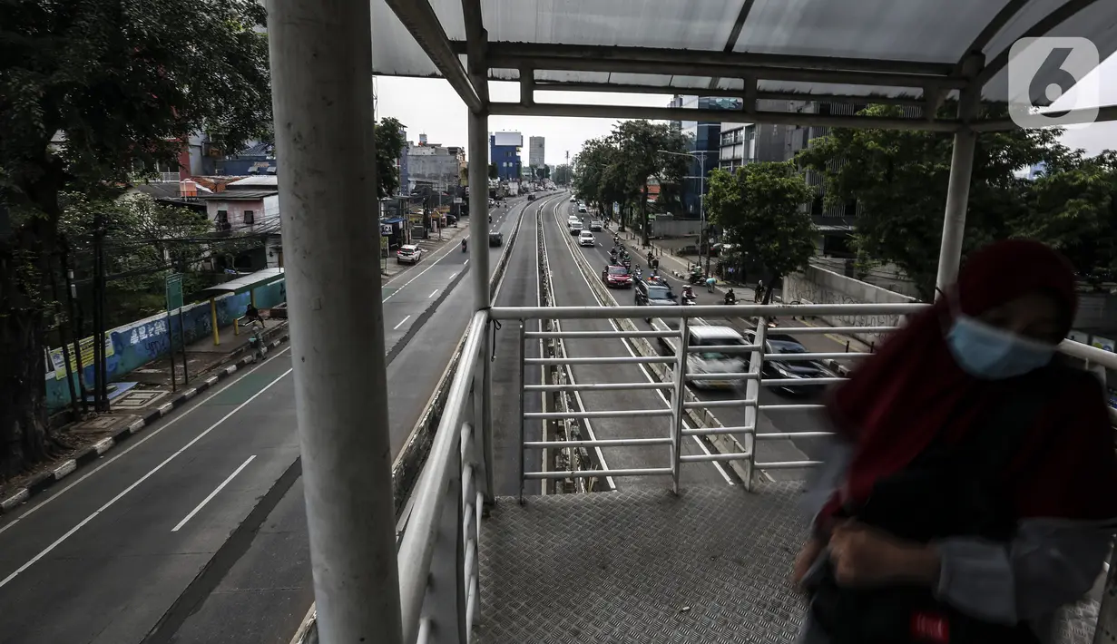 Warga berjalan di JPO Jalan Warung Buncit Raya yang kini diganti dengan nama Jalan Hajah Tutty Alawiyah, Jakarta, Senin (27/6/2022). Gubernur DKI Jakarta Anies Baswedan baru saja mengganti 22 nama jalan di Jakarta, salah satunya Jalan Warung Buncit Raya. (Liputan6.com/Johan Tallo)