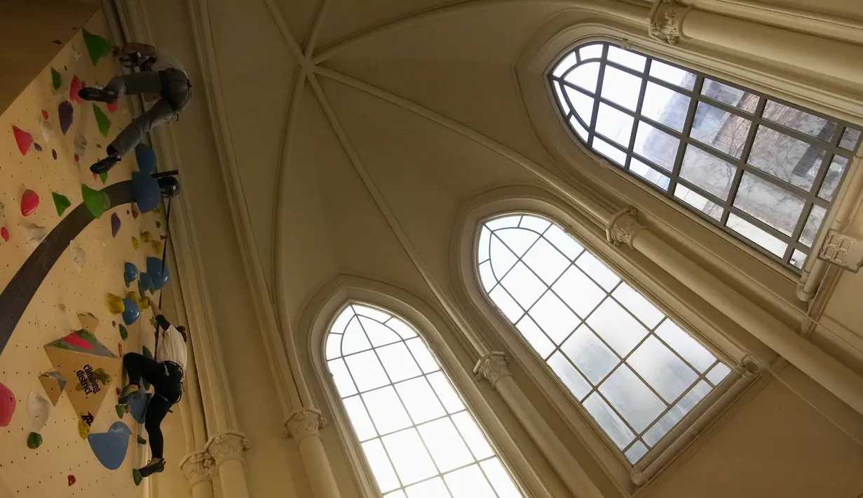 Peserta berlatih memanjat di lokasi Climbing District di Paris, Rabu, 11 Januari 2023. Tembok panjat buatan baru ini dibuka pada November 2022 di dalam bekas kapel abad ke-19, bernama le couvent des Oblats de Marie-Immaculee. (AP Photo/Christophe Ena)